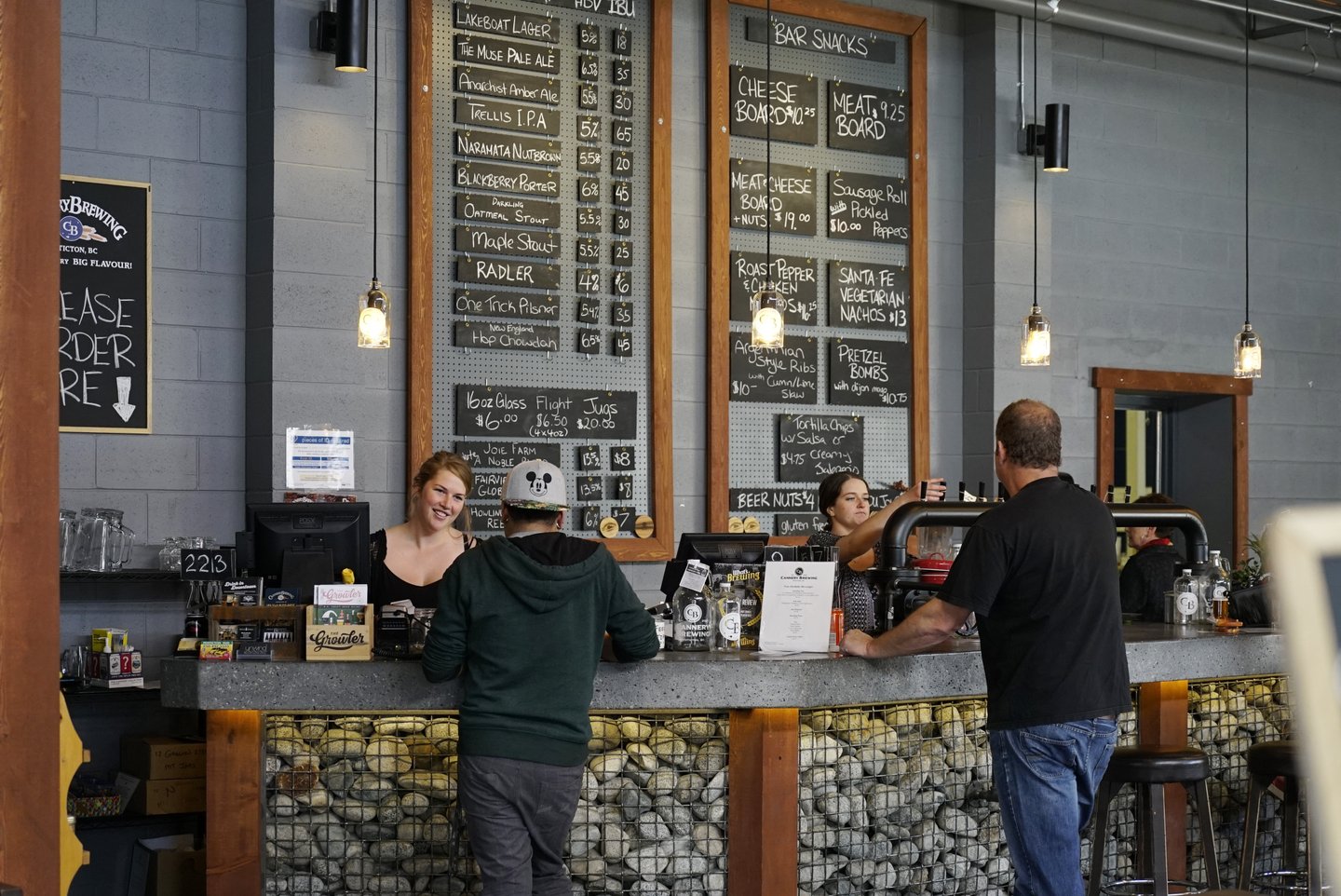 Customers standing at tasting room bar inside Cannery brewing