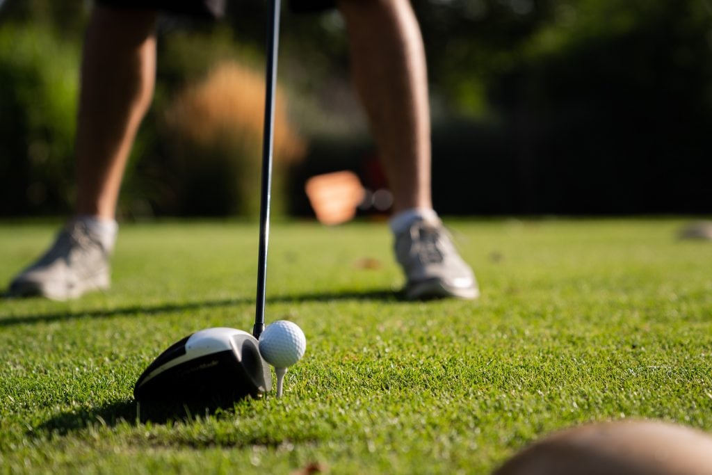 Close up picutre of a golfer lining up tee shot with driver